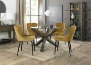 The Bentley Designs Impress your guests with the Bentley Designs Turin Clear Tempered Glass 4 Seater Dining Table with Dark Oak Legs & 4 Cezanne Mustard Velvet Fabric Chairs with Sand Black Powder Coated Legs