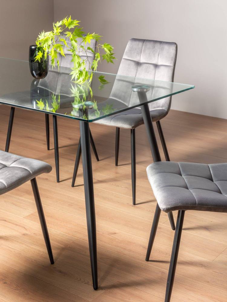Close Up of The Bentley Designs Martini Clear Tempered Glass 6 Seater Dining Table & 4 Mondrian Grey Velvet Fabric Chairs with Sand Black Powder Coated Legs