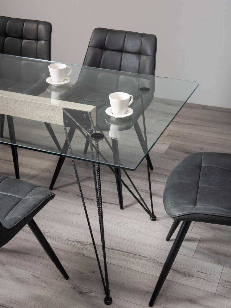 Close Up of the Bentley Designs Miro Clear Tempered Glass 6 Seater Dining Table & 6 Seurat dark Grey Faux Suede Fabric Chairs with Sand Black Powder Coated Legs