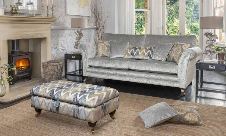 Grand Sofa in fabric 9607, large scatter cushions in 9333, small scatter cushions in 9827, lumbar cushion in 9013, ebony bronze castor legs. Ottoman in fabric 9605 with ebony bronze castor legs