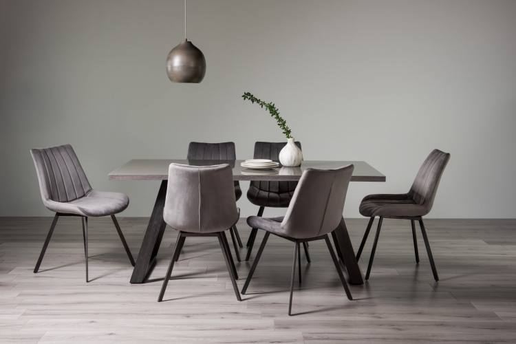 The Bentley Designs Hirst Grey Painted Tempered Glass 6 Seater Dining Table & 6 Fontana Grey Velvet Fabric Chairs with Grey Hand Brushing on Black Powder Coated Legs