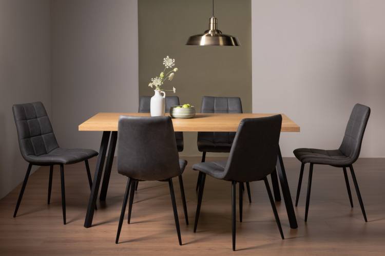 The Bentley Designs  Ramsay Oak Effect Melamine 6 Seater Dining Table with 4 Legs & 6 Mondrian Dark Grey Faux Leather Chairs with Sand Black Powder Coated Legs