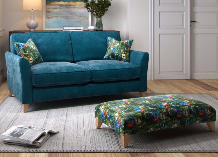 Sofa shown in room setting in Villa Teal fabric with scatters in Sabor Jewel 