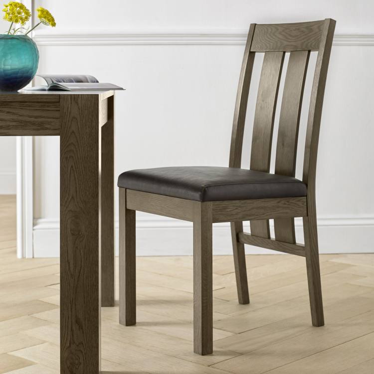 The bentley Designs Turin Dark Oak Slatted Chair in Distressed Bonded Leather on Display