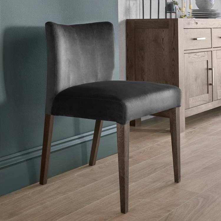 The Bentley Designs Turin Dark Oak Low Back Uph Chair in Gun Metal Velvet Fabric on Display